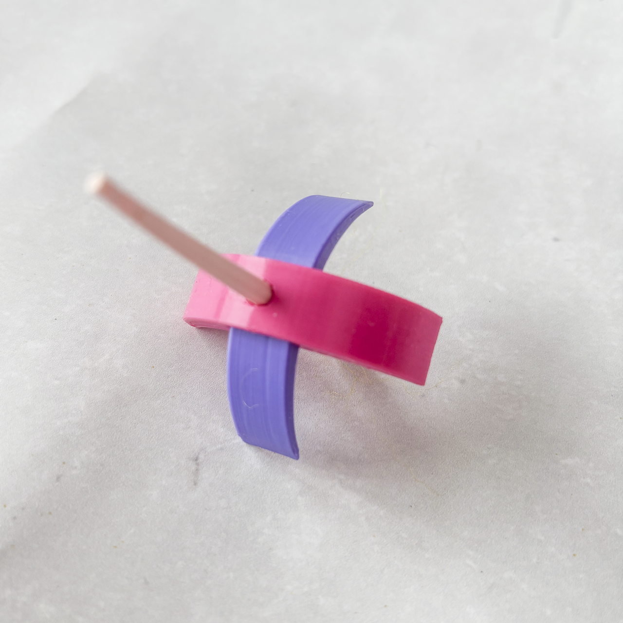 Pink and purple 3d printed Turkish spindle on a white background