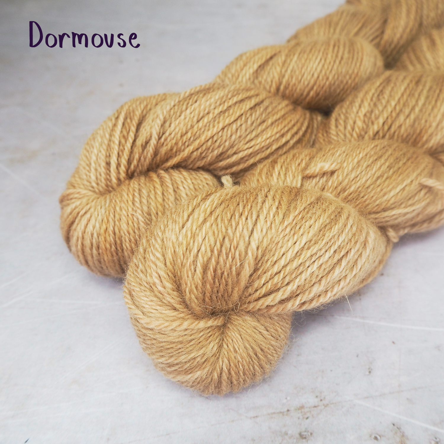 Two skeins of hand-dyed yarn in soft fawn.