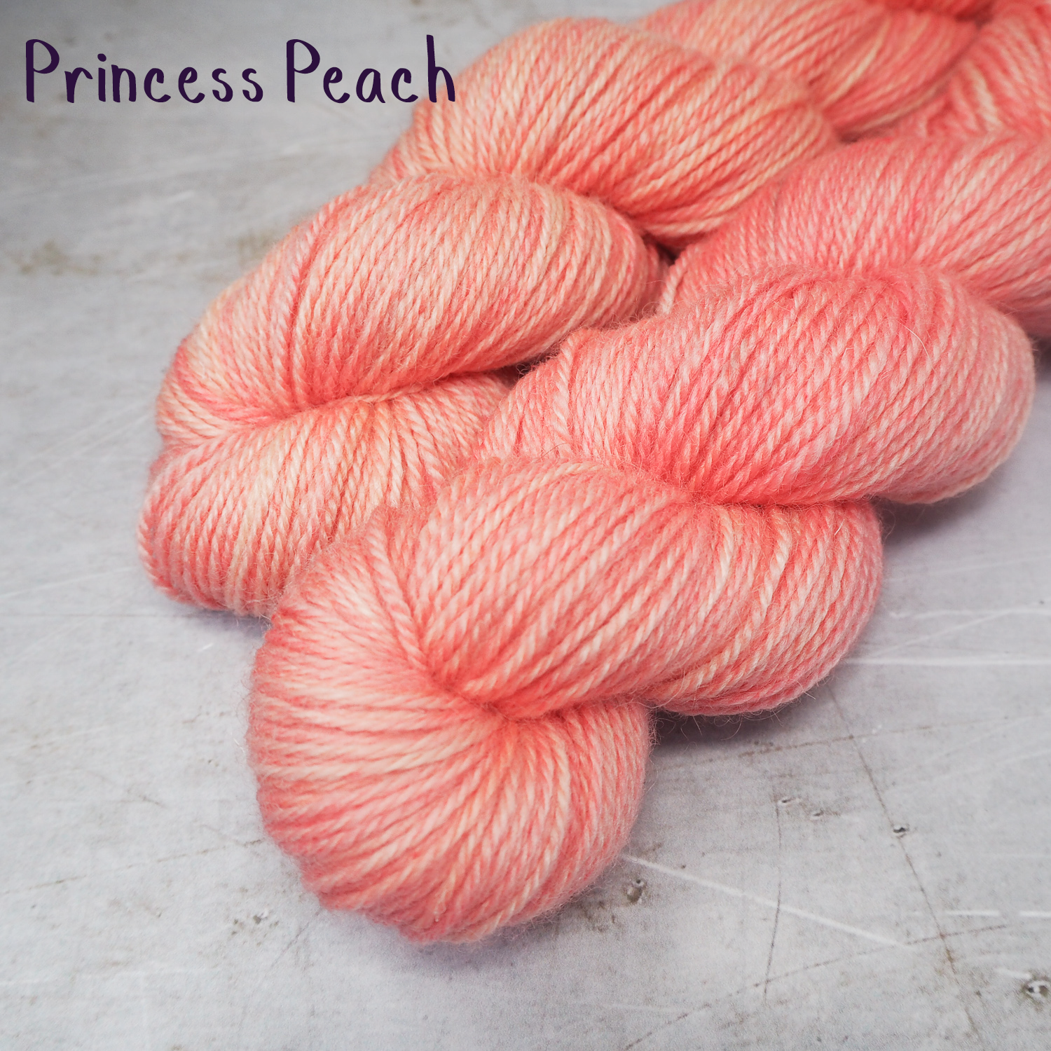 Two skeins of soft DK weight yarn dyed a rich peach colour.