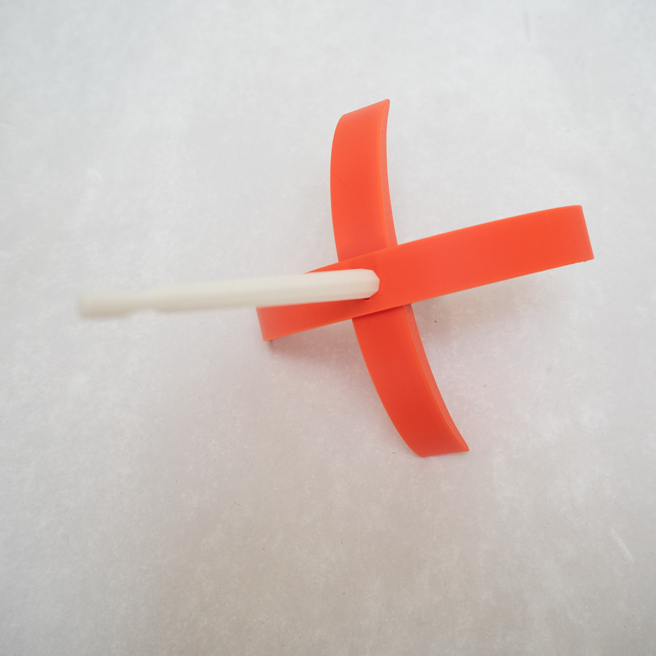 A bright orange Turkish drop spindle