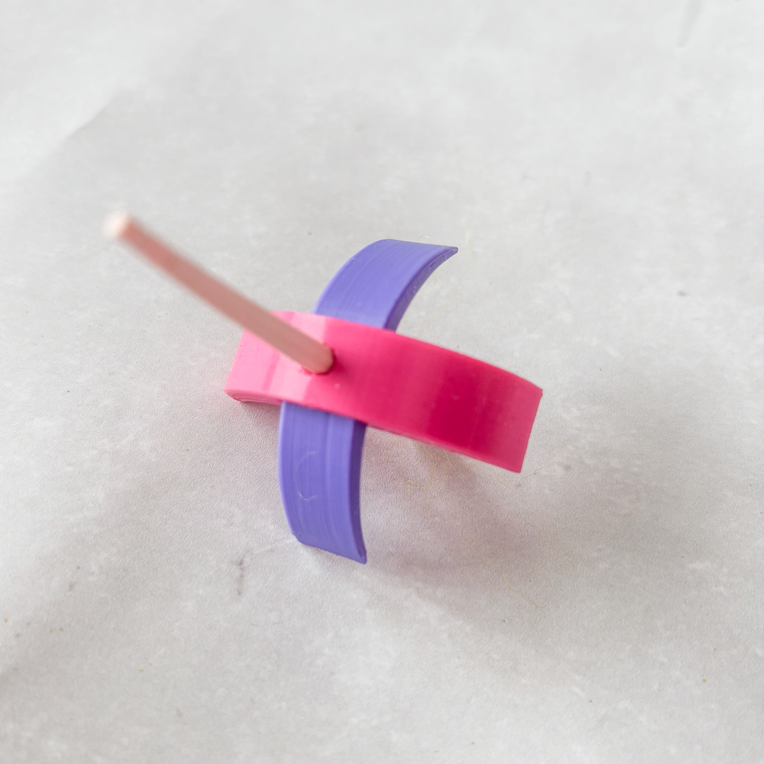Pink and purple 3d printed Turkish spindle on a white background