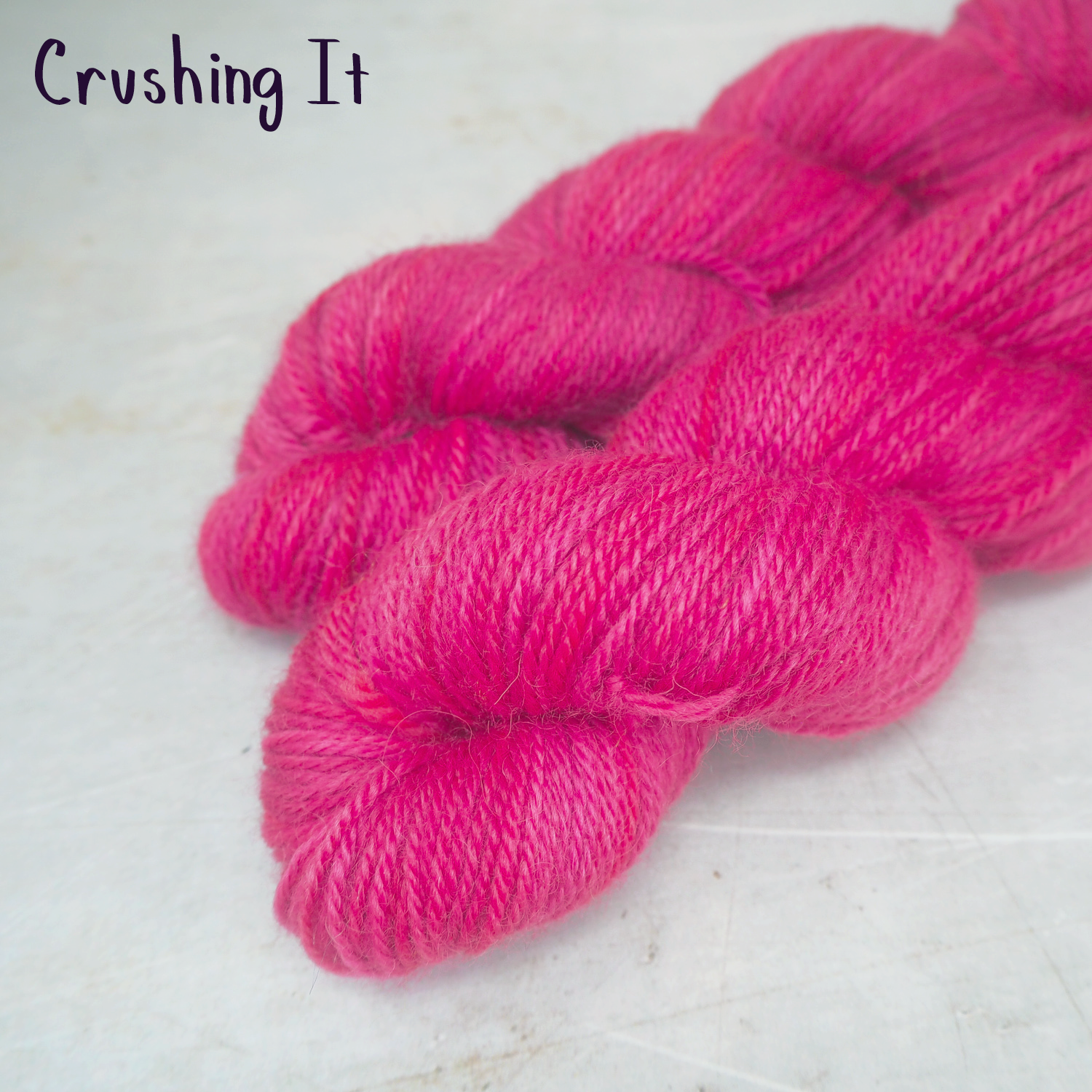 Two skeins of soft, DK weight hand-dyed yarn in hot pink. 