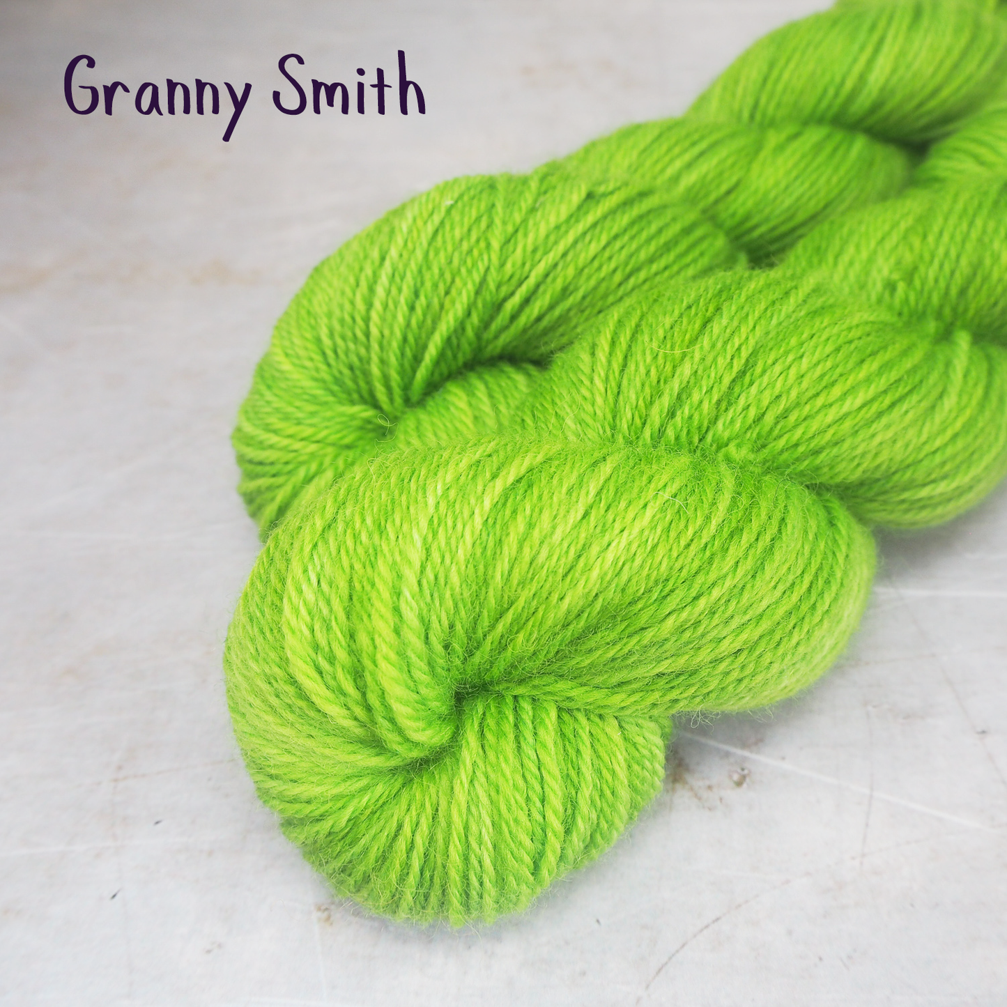 Two skeins of soft, DK-weight yarn, hand-dyed a vibrant lime green. 