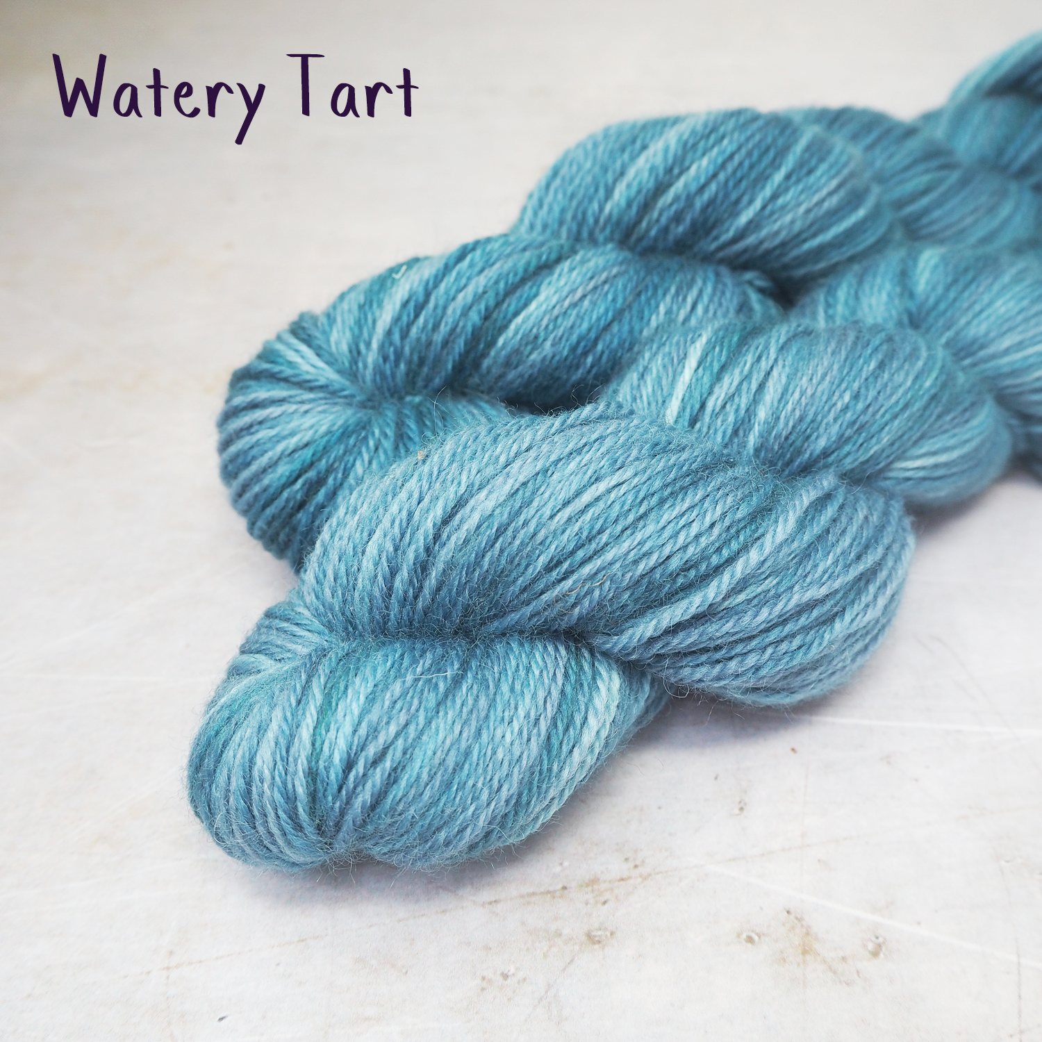 Two skeins of soft, DK-weight yarn, hand-dyed in variegated mid-blues. 